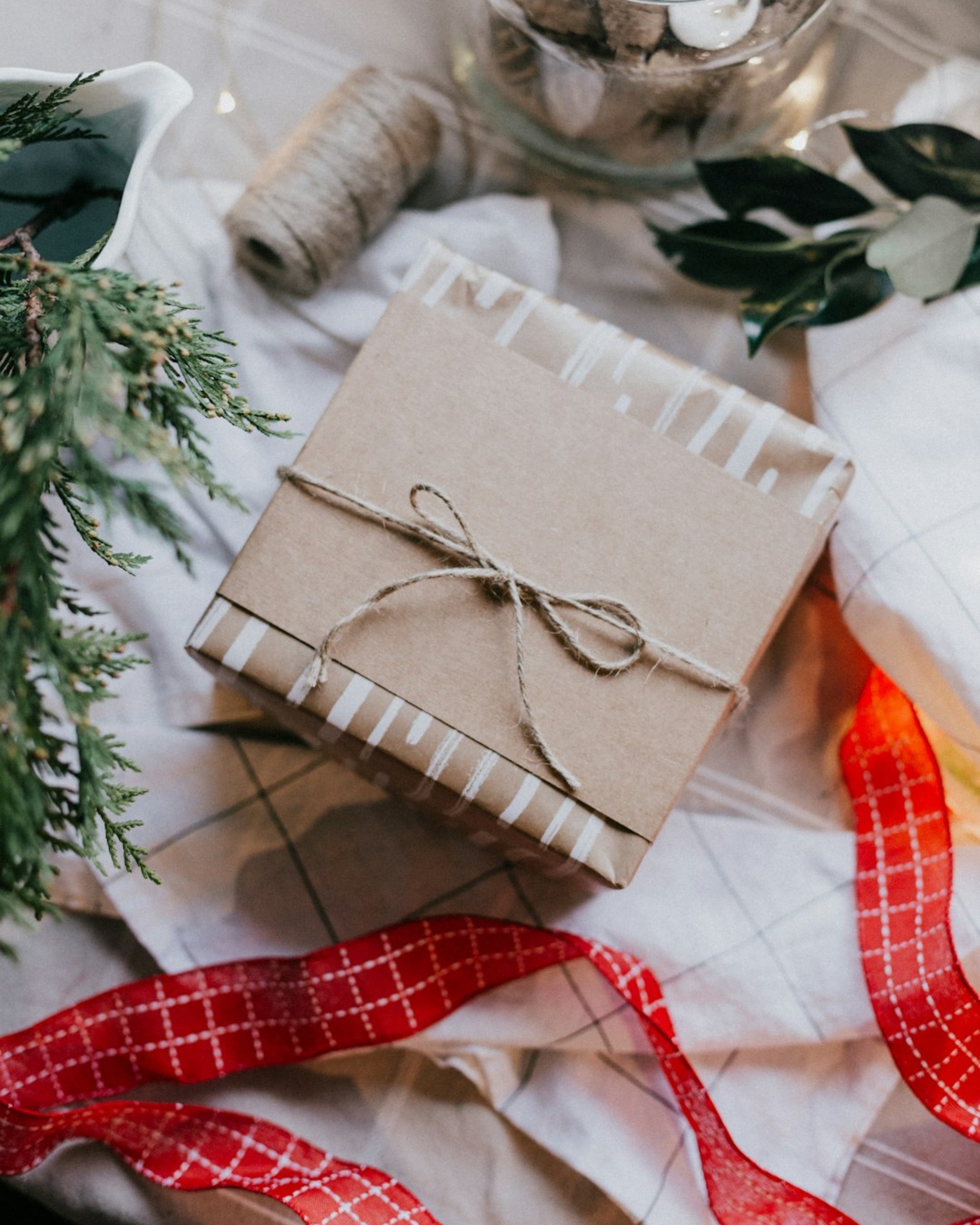 Image of wrapped gifts with holiday items in the background