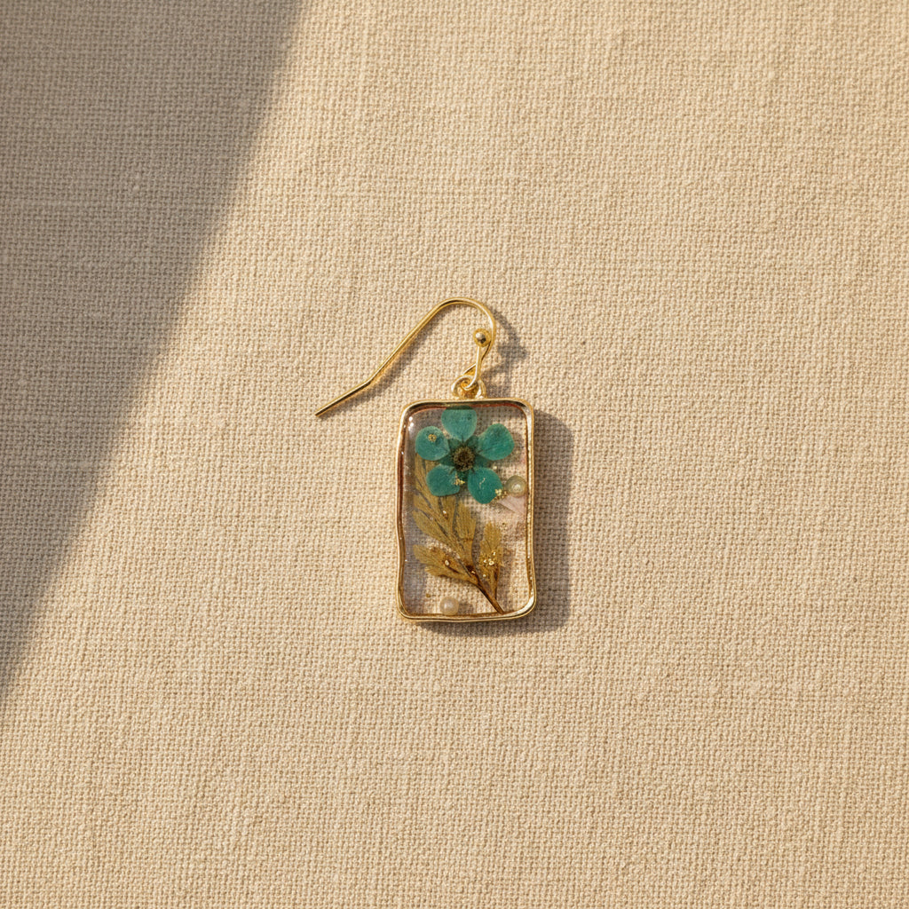 Close-up of botanical turquoise and green leaf details embedded in resin on a textured background