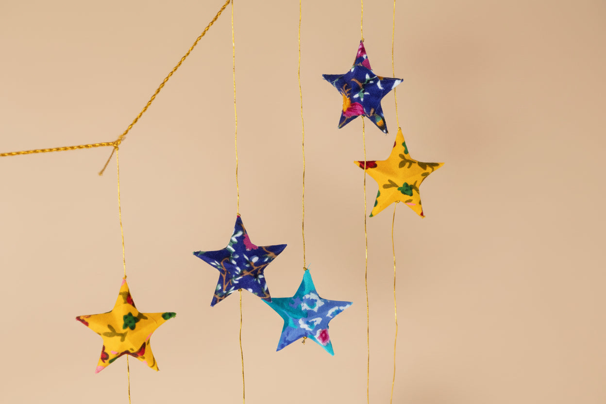 Colorful star-shaped decorations hanging on a white background
