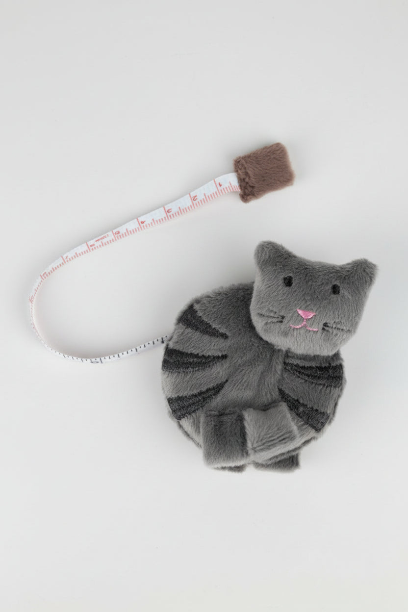 A gray fabric cat tape measurer on a white background