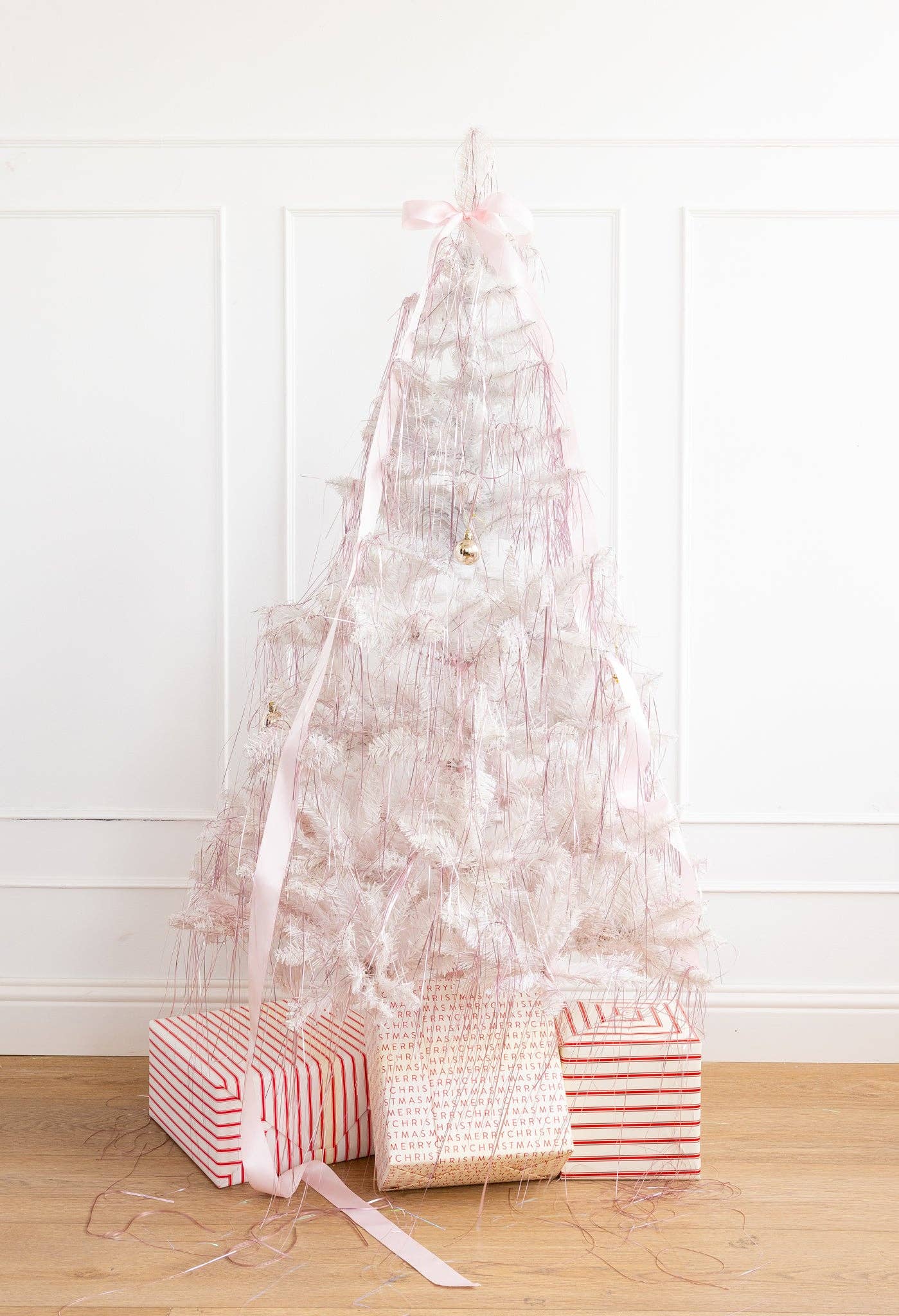 Pink tinsel strands adding colorful sparkle to a Christmas tree