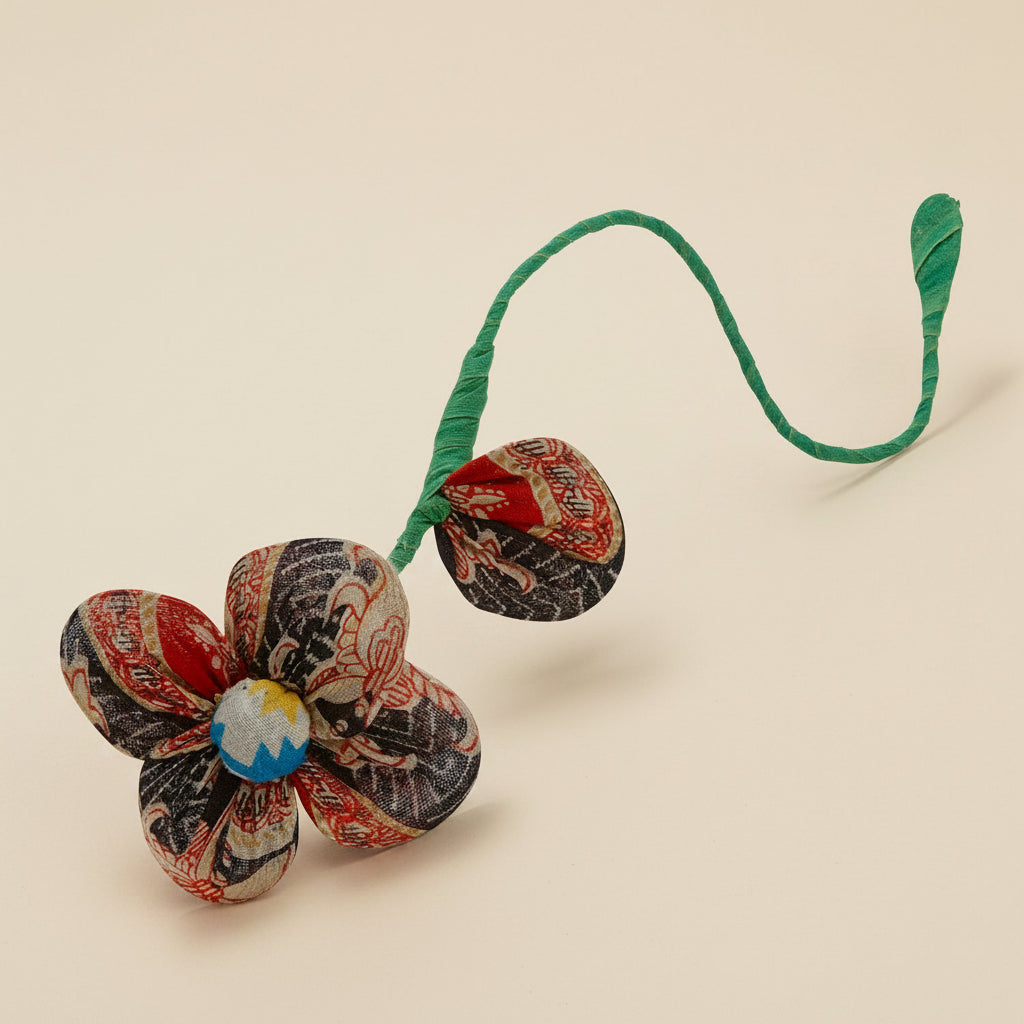 Brightly colored recycled sari flower with bendable stem on white background