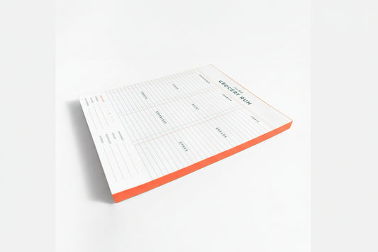 Notepad with a grocery list template on a white background