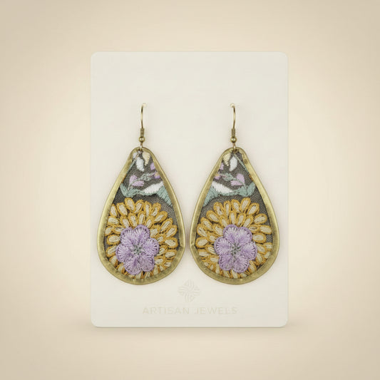 Teardrop-shaped earring with floral design shown on a backing card on a white background