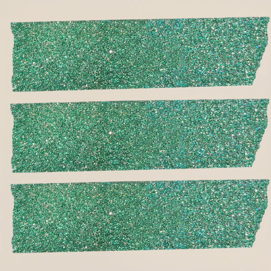 Green glittery washi tape added to holiday gift wrap with holiday packages and other elements on a light beige background