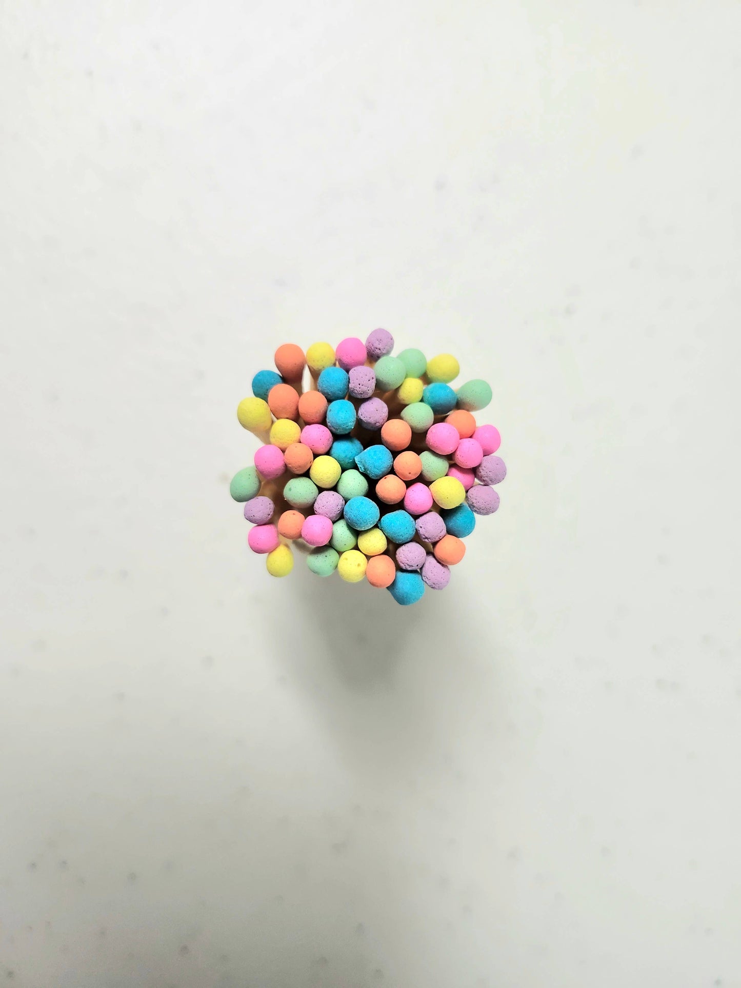 Close up of the colorful neon matchsticks in a corked glass vial.