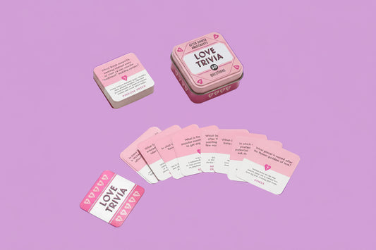 Love Trivia game cards in a pink tin on a pink background
