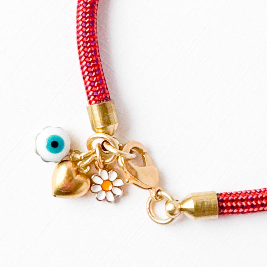 Close-up of the tiny brass heart and enamel evil eye charm