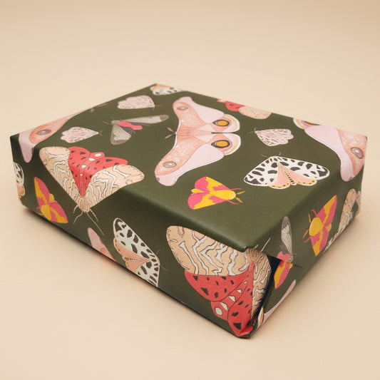 Pink moths decorate a dark craft paper making this irresistible moth gift wrap paper for all fall gifts on a white background