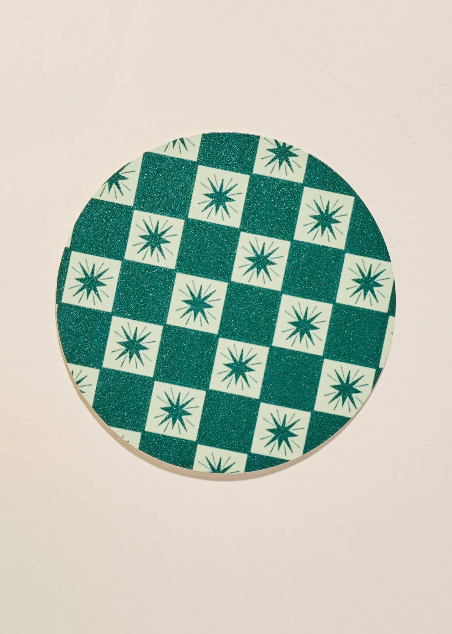 Close up of one green checkered and star coaster.