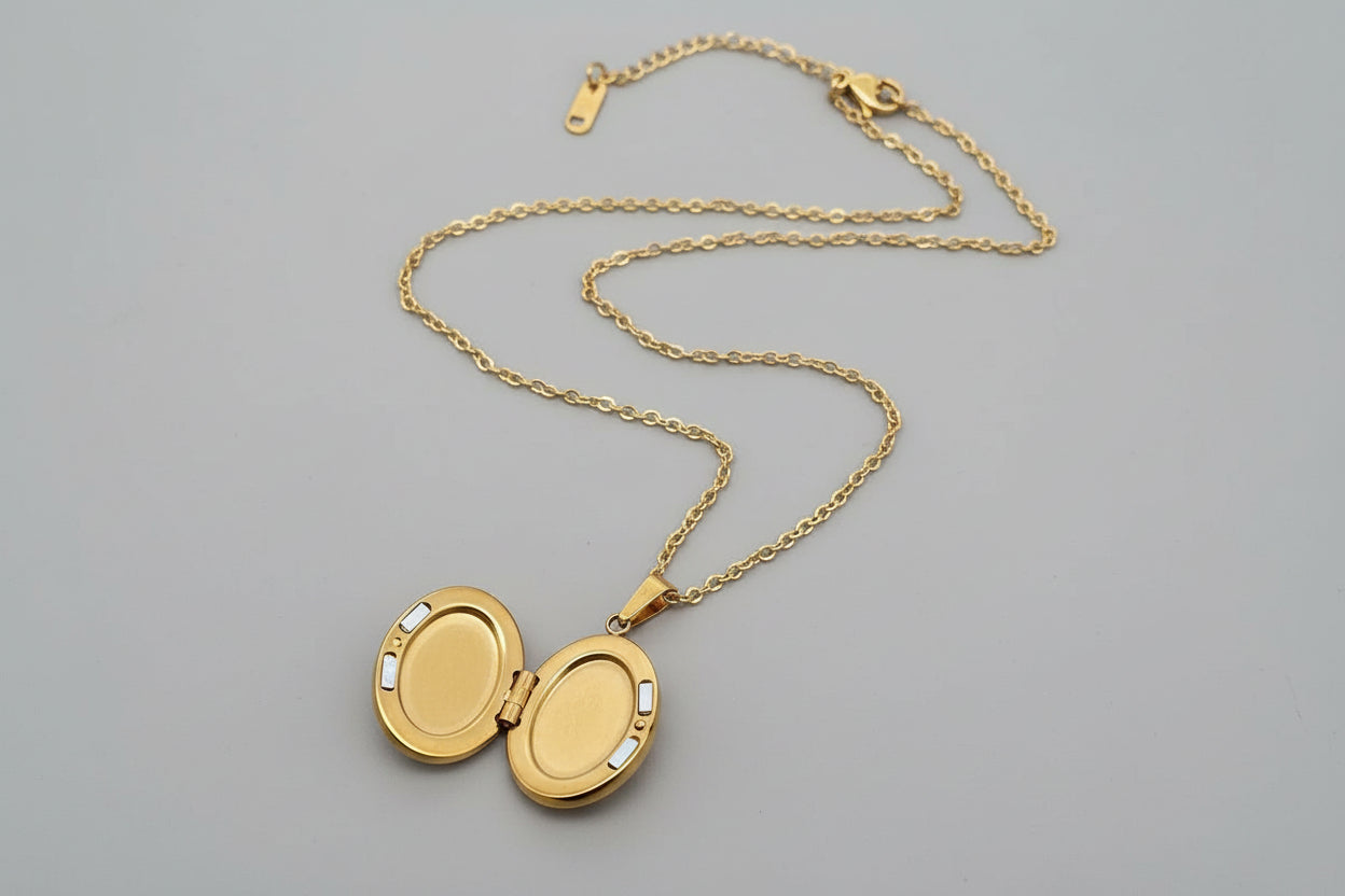 Gold locket necklace on a gray textured surface