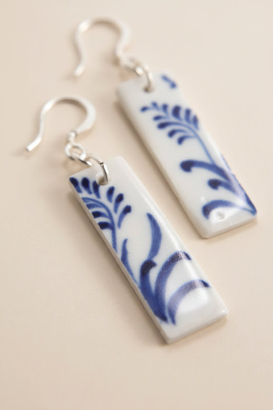 Close-up of Bat Trang ceramic earrings with French hooks and unique floral motifs