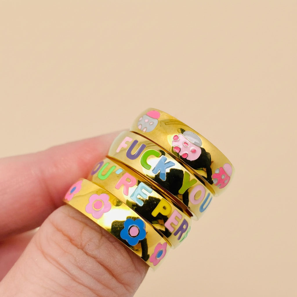 Gold rings with colorful text and designs on a white background