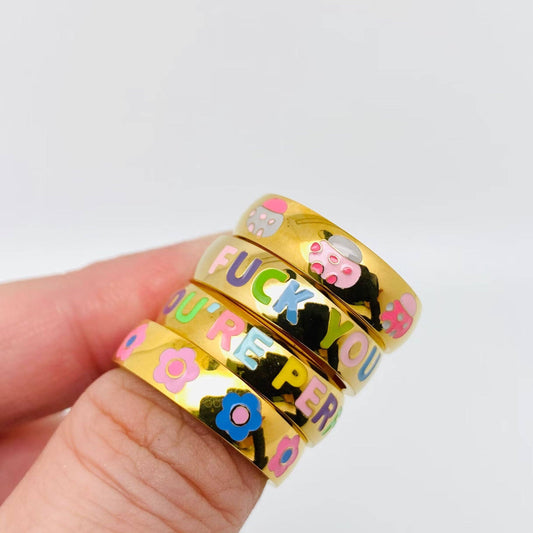 Gold rings with colorful text and designs on a white background