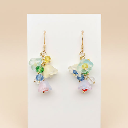Colorful floral earrings on a white stand with a light gray background