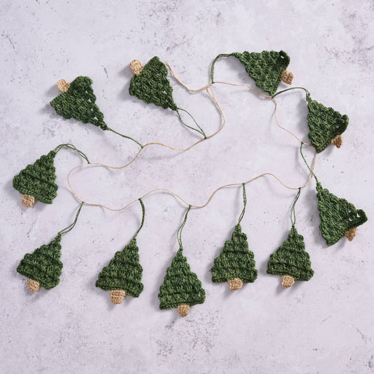 The Holly Jolly Trees Crochet Garland laid out on a marble countertop showcasing the length and amount of trees on each garland