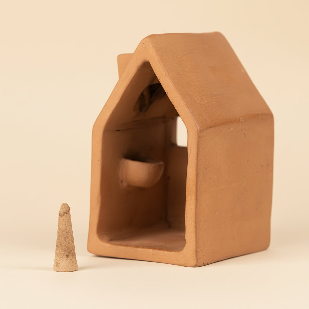 Terracotta incense house with a cone-shaped incense (not included) on a white background