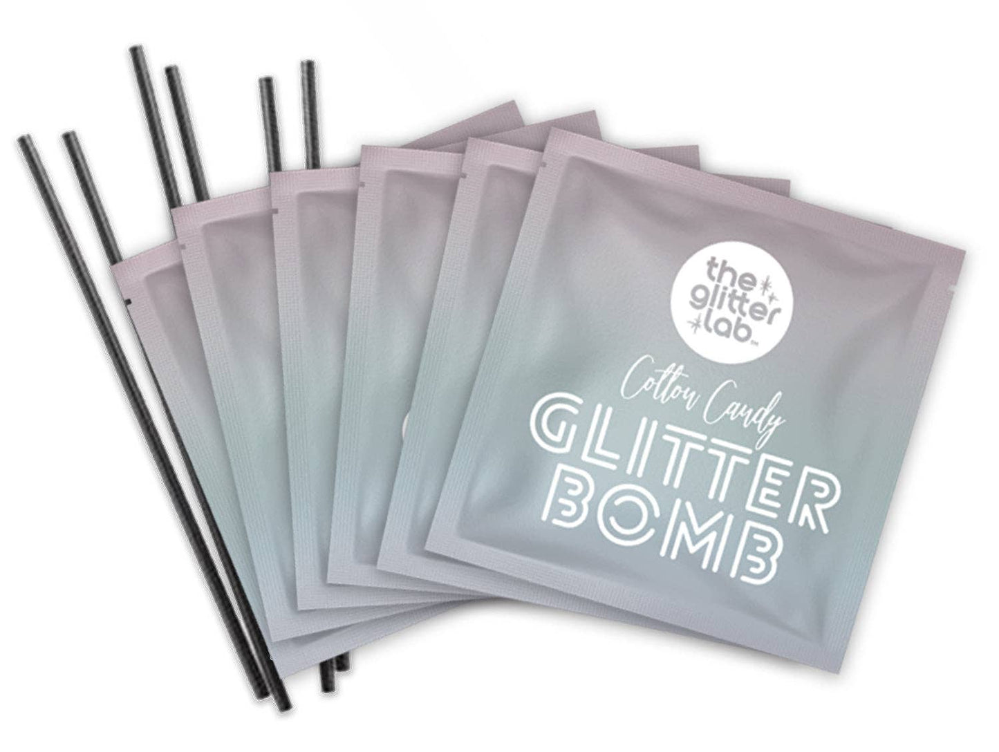 Close up of 5 Rainbow Glitter Bomb packets with stir sticks included in every box.