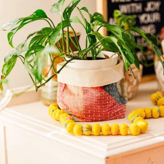 Decorative items including a plant, colorful beads, and a woven basket on a surface.