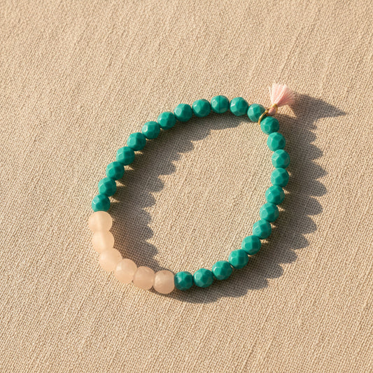 Beaded bracelet with turquoise and beige beads on a light beige background