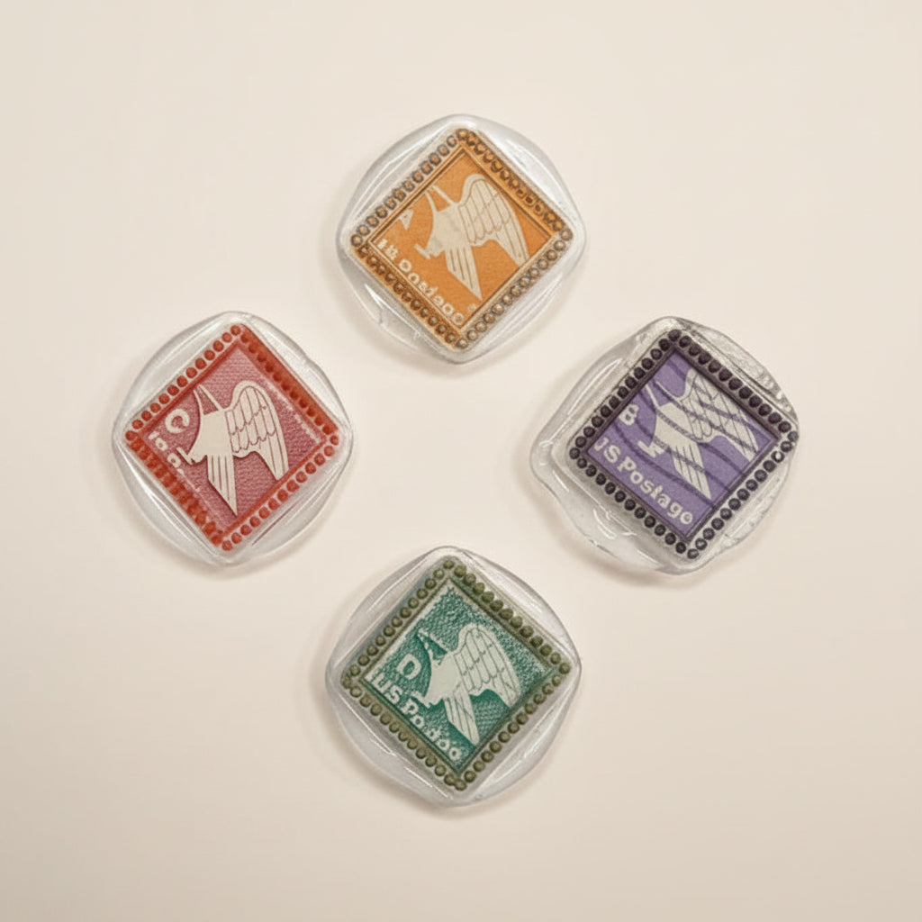 Four vintage-style postage stamp magnets created by Rochambeau Home by stamping in clear wax and multi-color gilding wax to showcase the details.