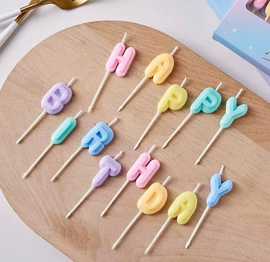 Close-up of colorful gradient candles spelling “HAPPY BIRTHDAY”