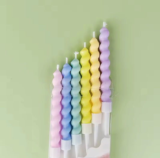 Close-up of pastel gradient candles with plastic caps