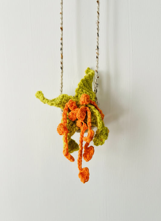 Close-up of textured yarn leaves and floral details on crocheted plant