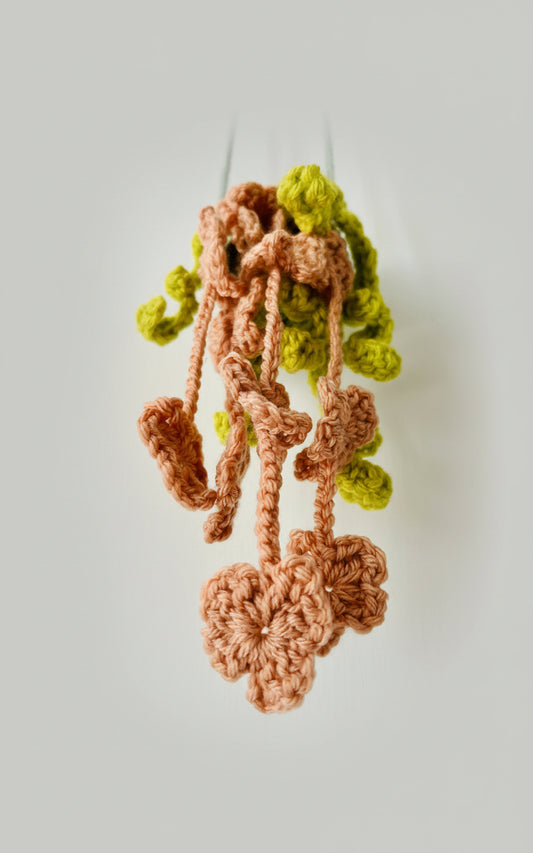 Botanical-inspired fiber art plant with gentle, heart-shaped leaves cascading from crocheted strands.