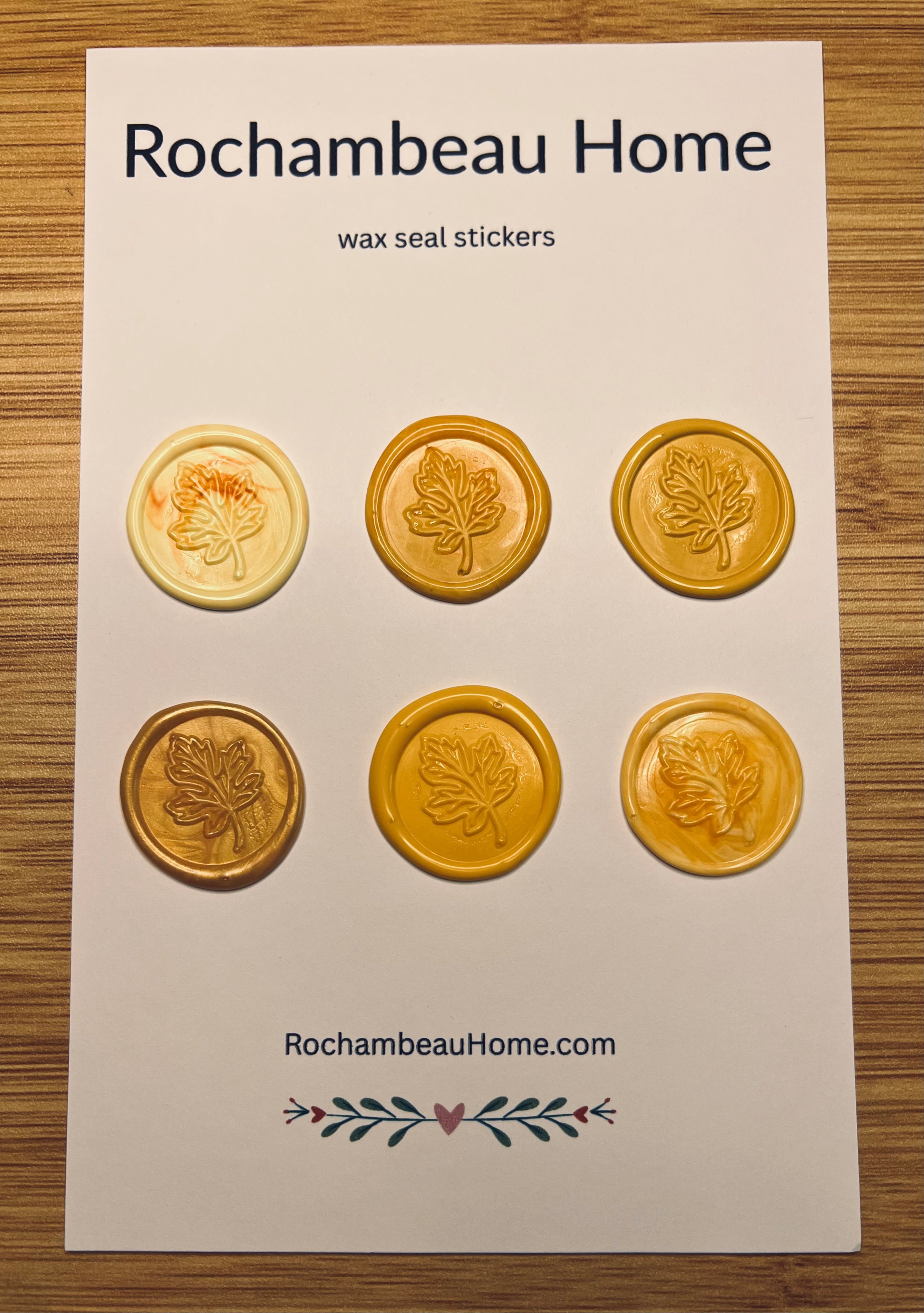 Packaging of Rochambeau Home Falling for You Maple Leaf Wax Seal Stickers on a wooden surface