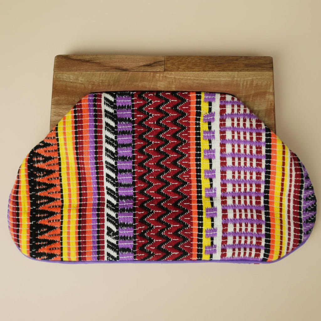 Colorful patterned pouch on a wooden block against a white background