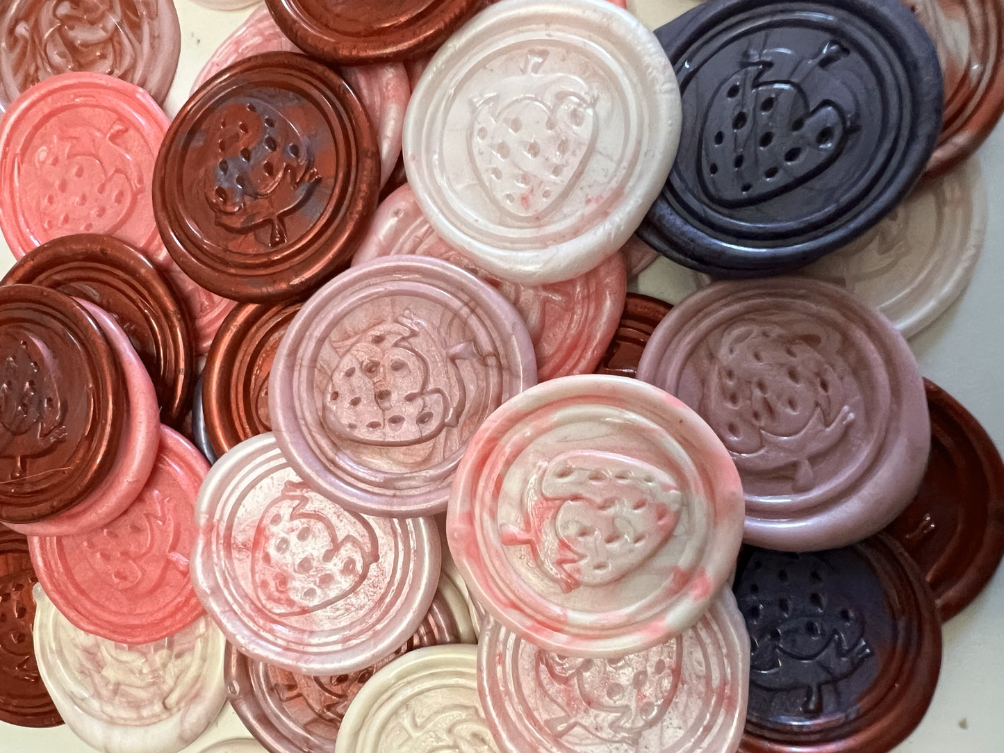 Pink and red wax seal with detailed strawberry motif, bursting with charm.
