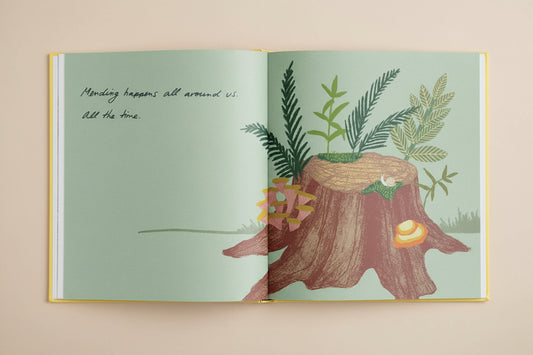 Illustrated book open to a page with a tree stump and plants on a light green background.