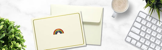 Rainbow notecard laying flat on desk with self seal envelope