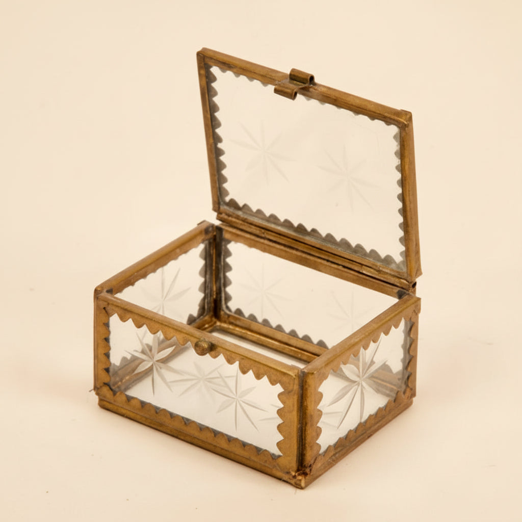 A brass and etched glass box, perfect for holding jewelry on a white background