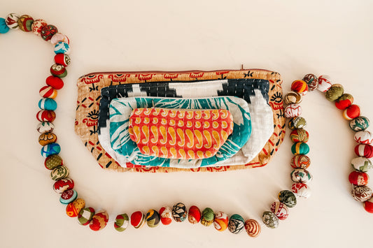 Colorful stack of pouches with patterned contents on a white background