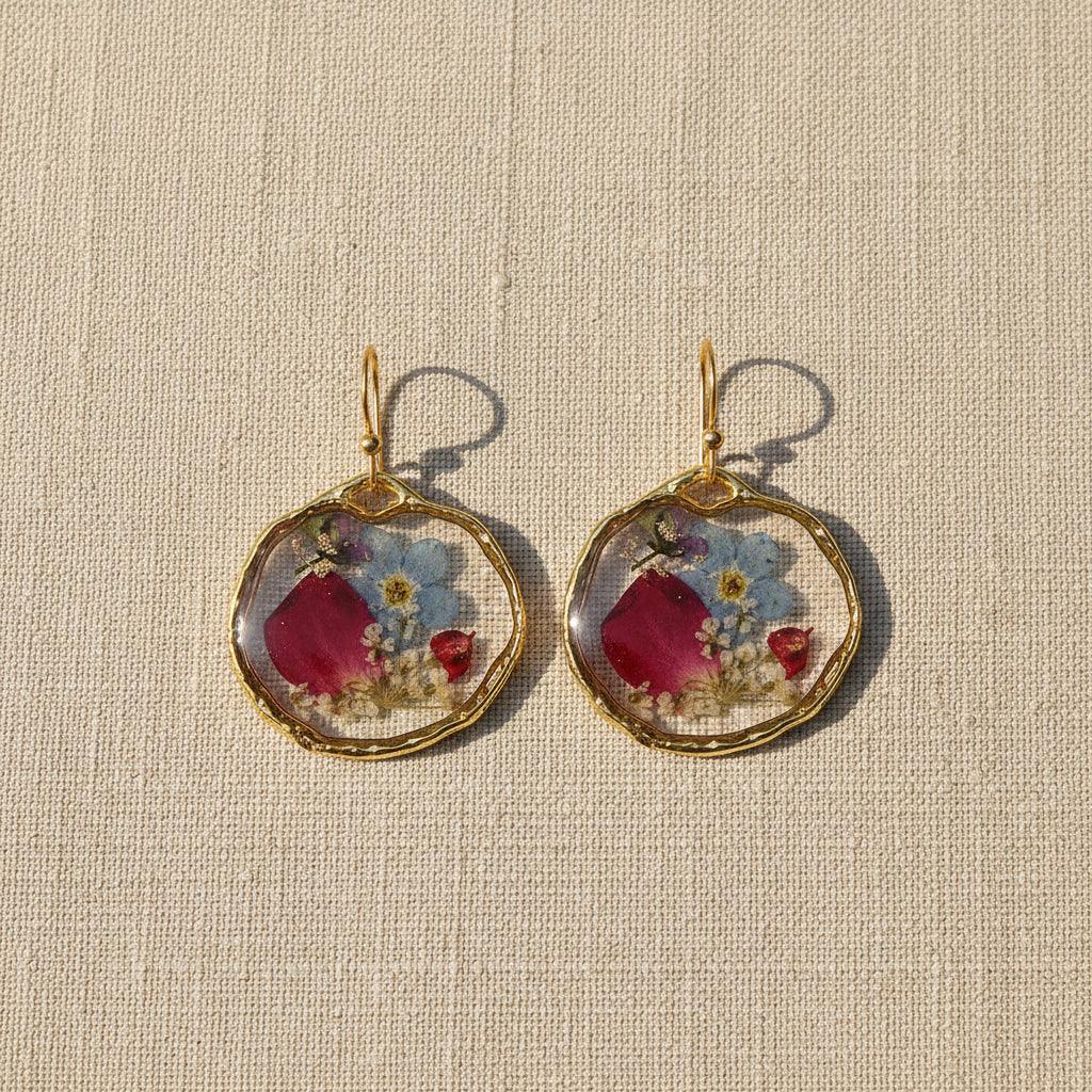 Pair of earrings with floral designs from Rochambeau Home on a natural background