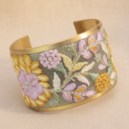 Floral embroidered cuff bracelet on a light beige background