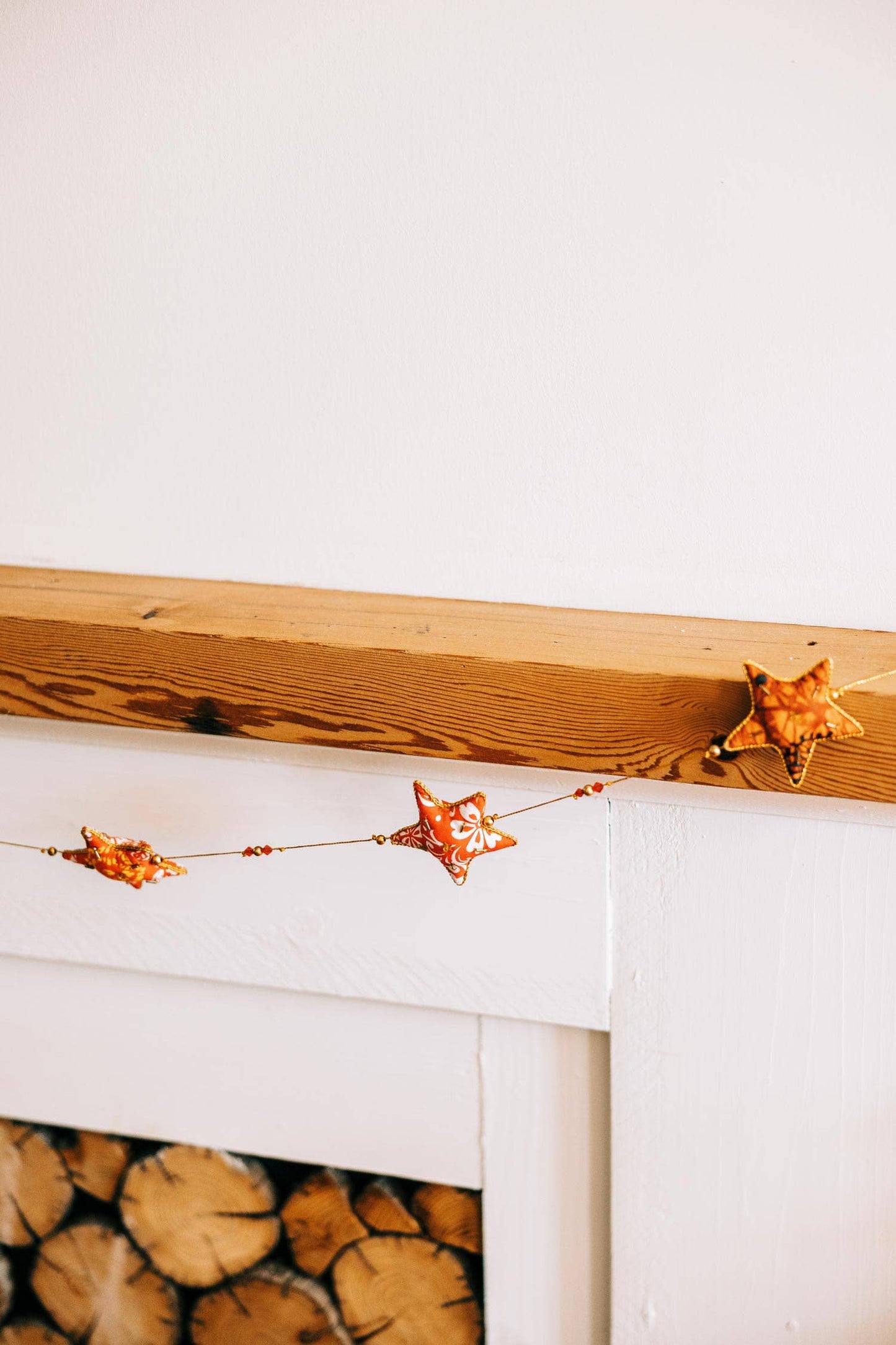 Handcrafted star garland draped across a mantle with warm and rich wood tones