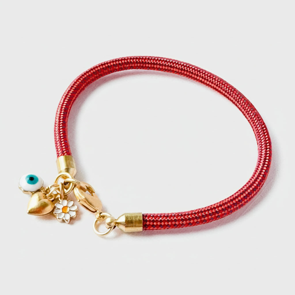 Red paracord charm bracelet with evil eye, daisy, and gold heart on white background
