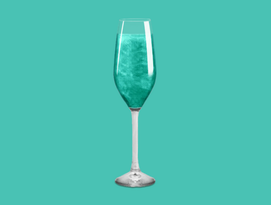 Teal Glitter Bomb in a champagne glass, transforming the drink into a dazzling teal creation.