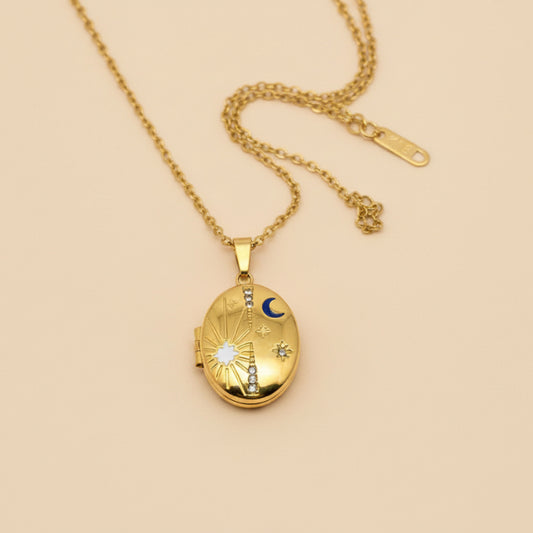 Gold locket necklace on a hand with a plain background