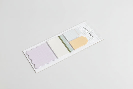 Set of sticky notes in various colors with a clear plastic cover on a white background