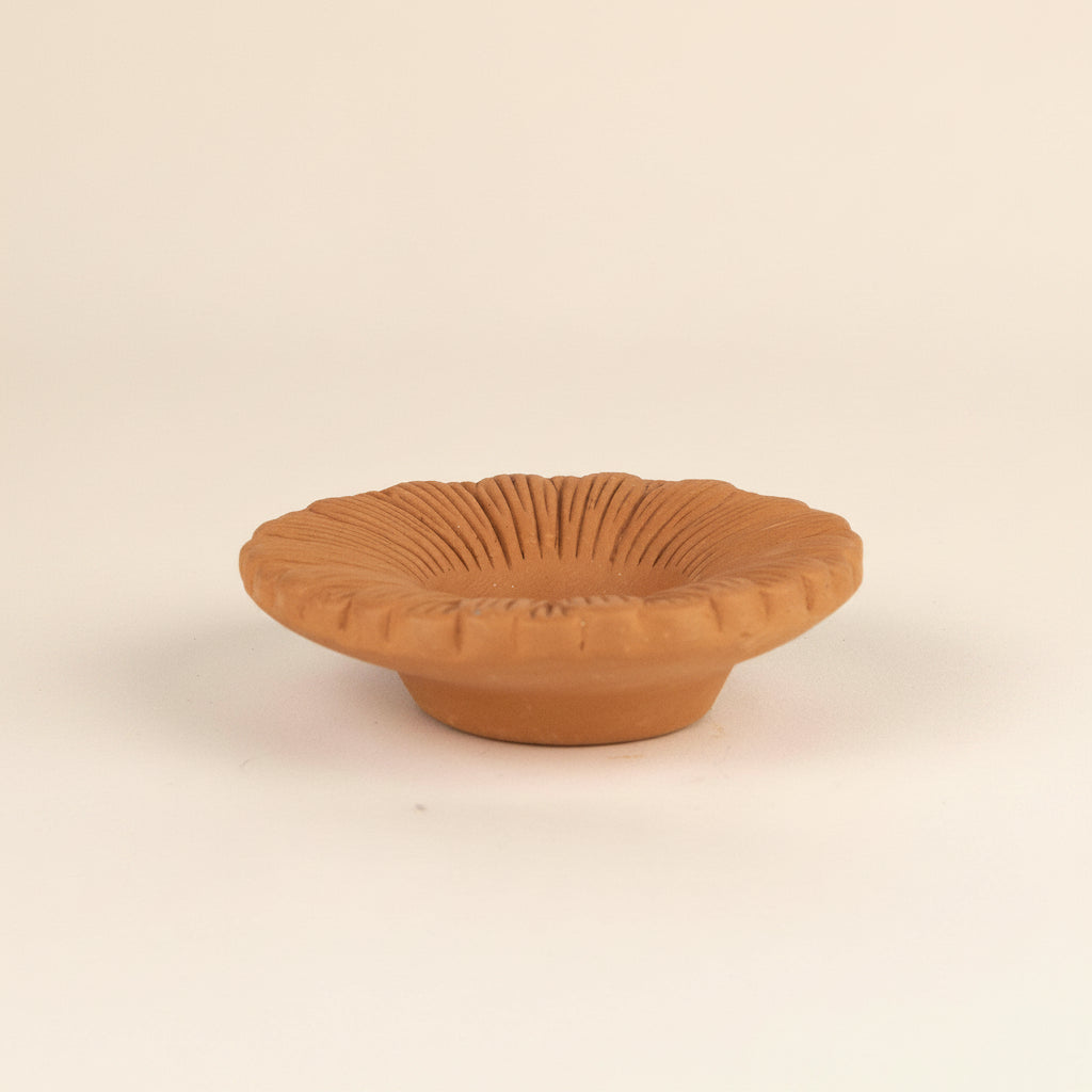 Terracotta bowl with textured surface on a white background