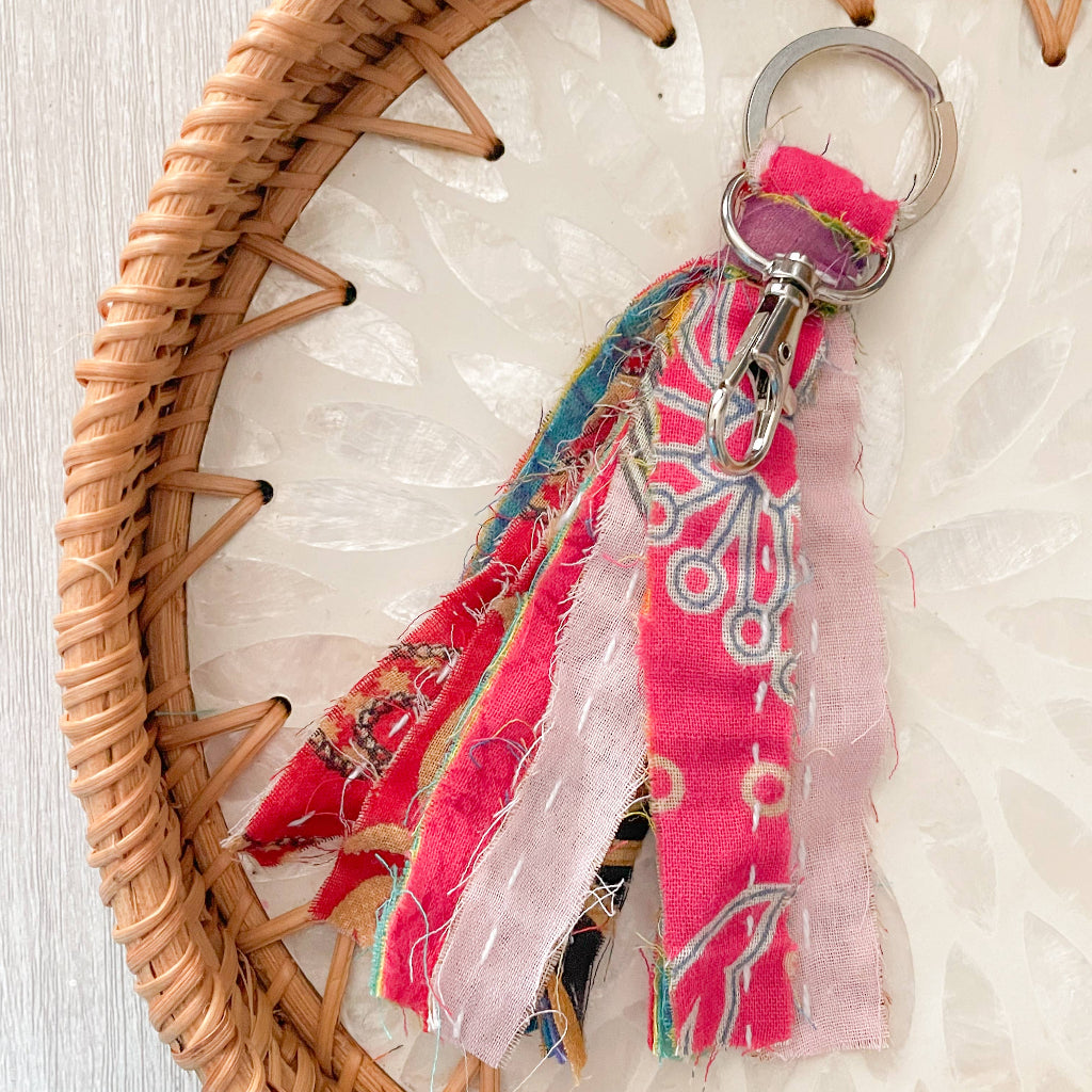 Colorful fabric keychain with a woven basket on a textured surface