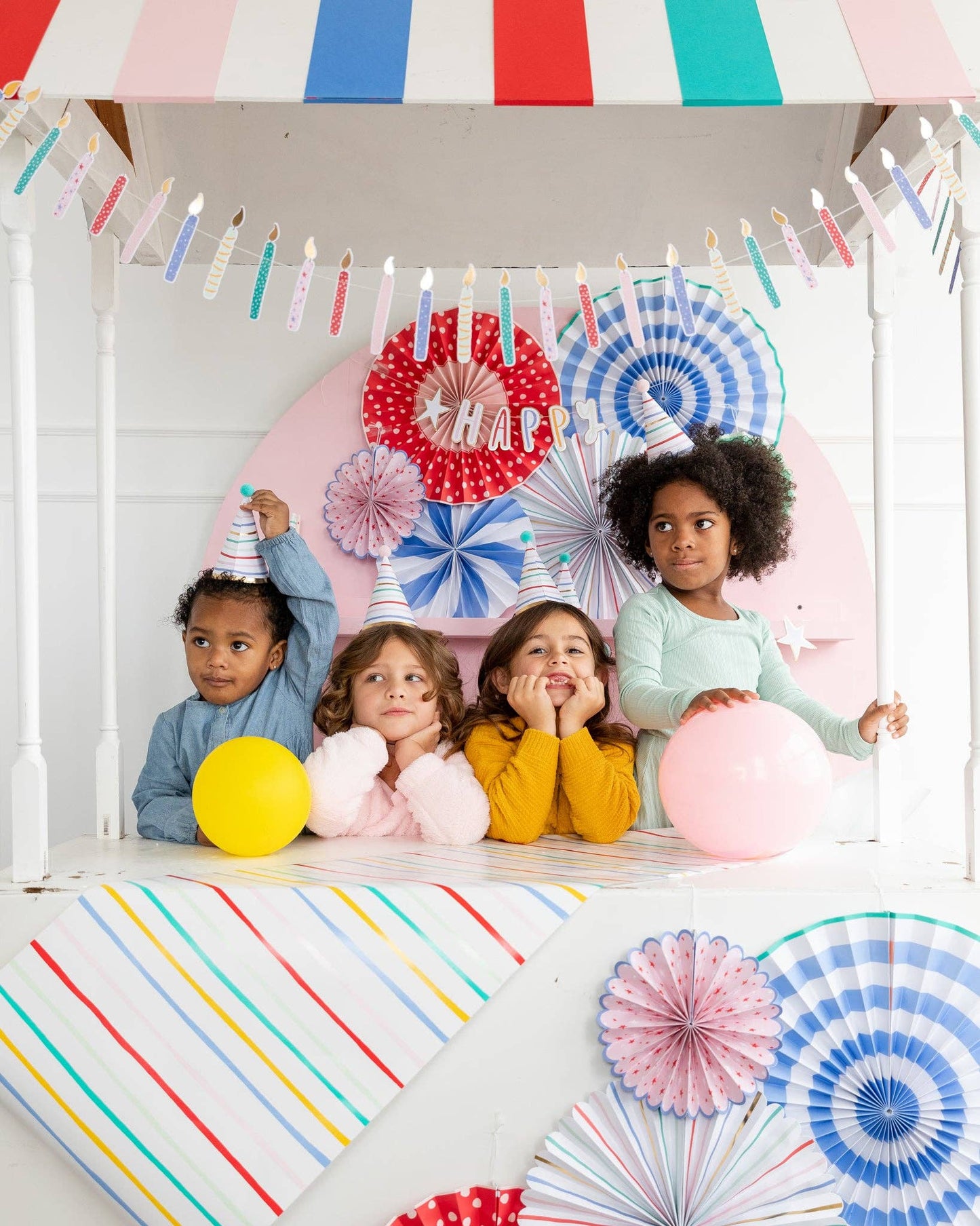 A group of children with party hats on with a festive and whimsical arty background
