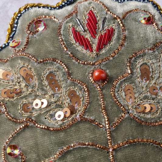 Close up view of the handcrafted sewing and beaded details on the ornament