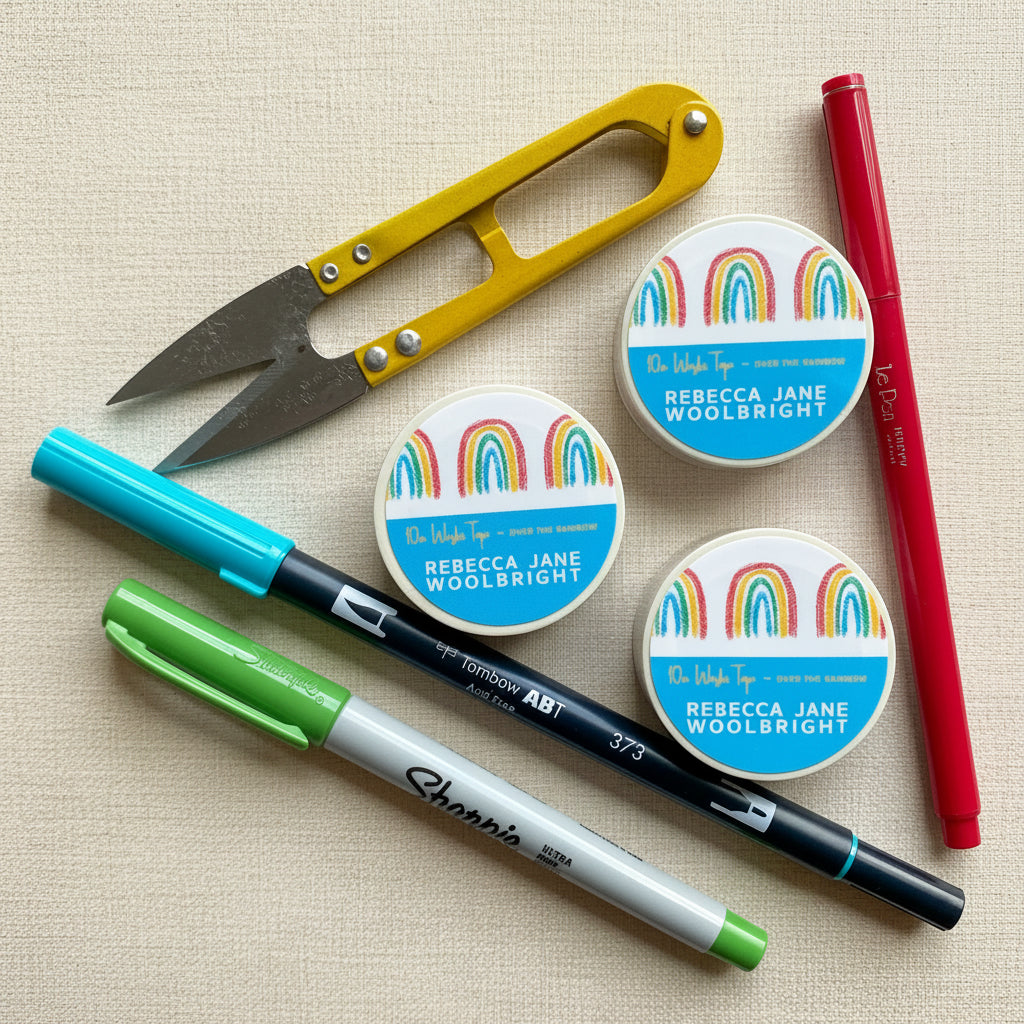 Roll of Over the Rainbow Washi Tape with label, next to scissors and stationery supplies