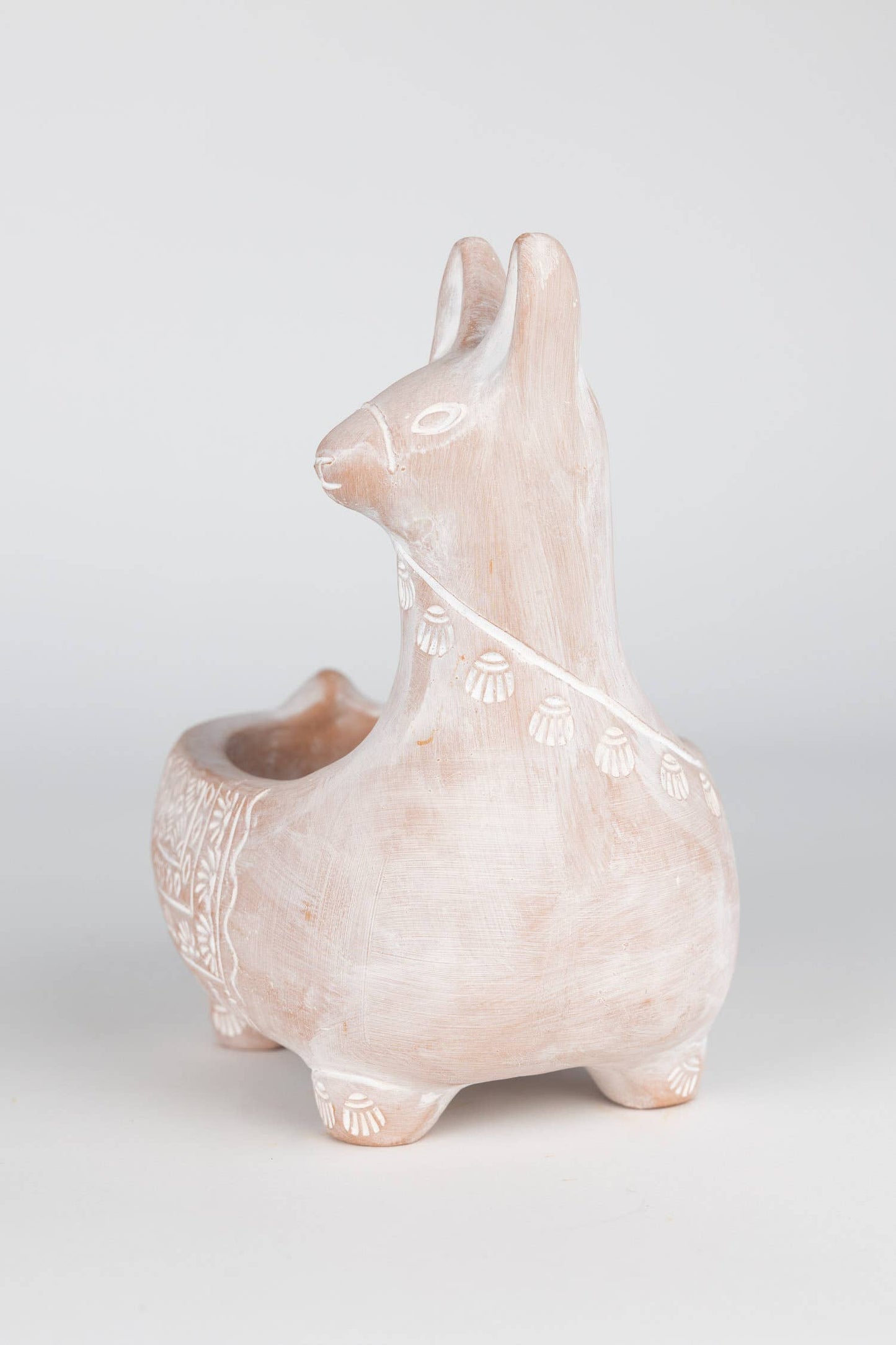 Ceramic llama-shaped planter on a light gray background