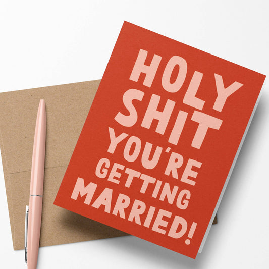 Close up of "Holy Shit You're Getting Married" greeting card with blank interior, Kraft paper envelope.